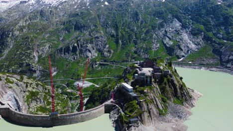 Aerial-drone-forward-moving-shot-over-Hotel-Grimsel-Hospiz-along-Grimsel-Pass,-Swiss-Mountain-in-Switzerland-on-a-sunny-day