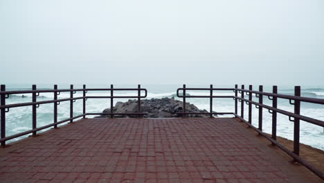 Static-shot-of-a-plum-pier-with-rocks-along-the-coast-of-Malecon-de-Miraflores,-Lima,-Peru