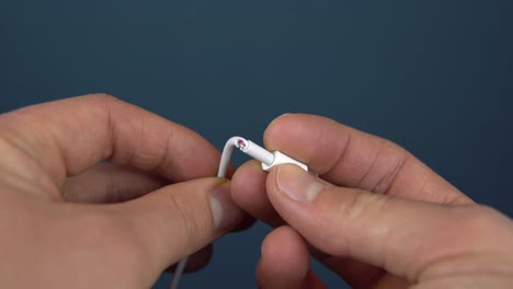 torn phone charger cable closeup. a man holds a torn wire in his hands. wire wear