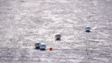 deporte de petanca, el jugador lanza la pelota para apuntar la pelota en la competencia