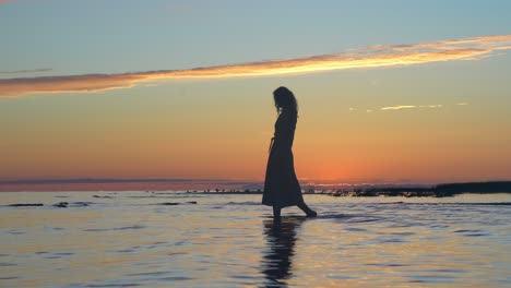 Mujer-Atractiva-En-Vestido-De-Verano-Caminando-Por-La-Costa-Del-Mar-Poco-Profundo