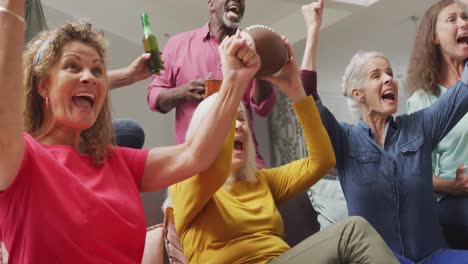 animation of happy diverse senior friends cheering while watching american football match in tv