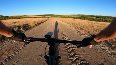 shadow of a cyclist cycling on a country road, first person capture