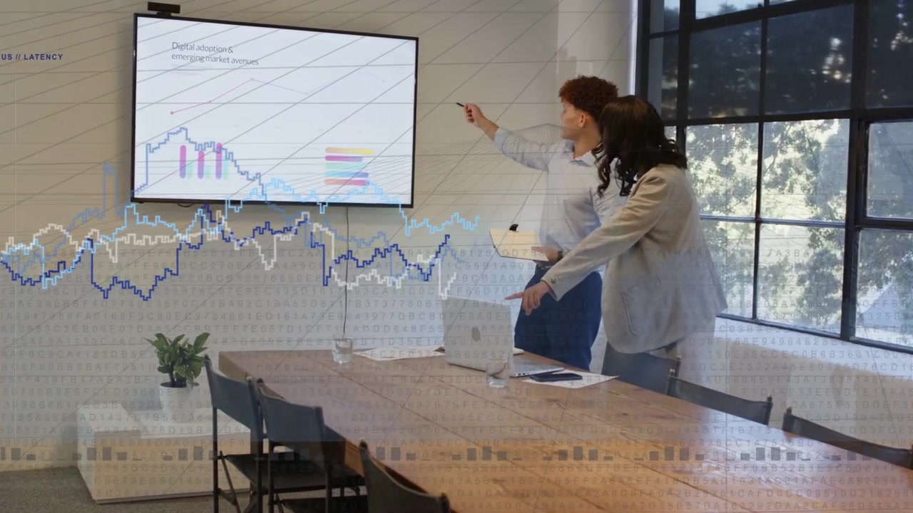 Man taking papers and pointing, woman at laptop, causing animated chart cues during business report
