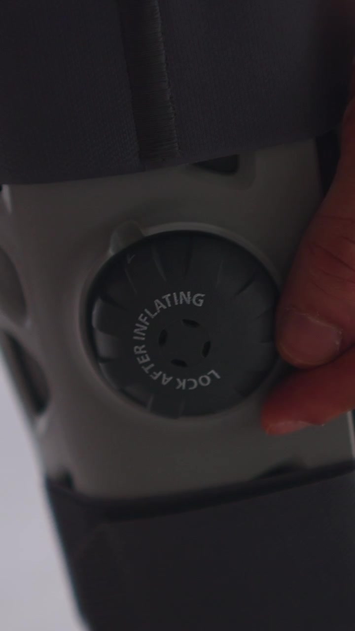 Person Adjusting Air Inflation Valve on Medical Orthopedic Leg Brace