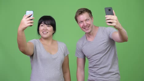 young happy multi-ethnic couple taking selfie