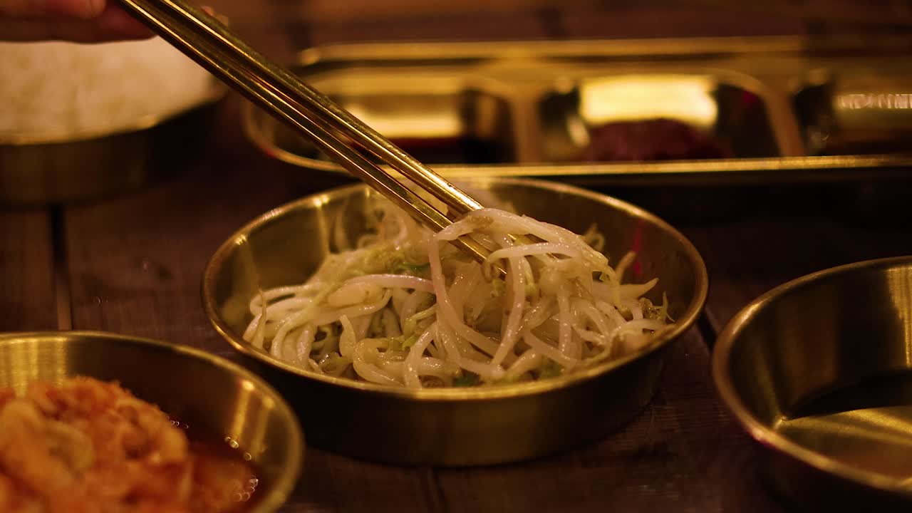 palillos para comer levantando brotes de frijol mungo del cuenco