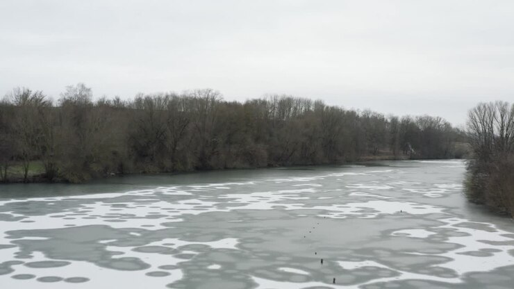 Riprese aeree con drone di un drone 4K che vola molto vicino sopra un lago ghiacciato in Germania