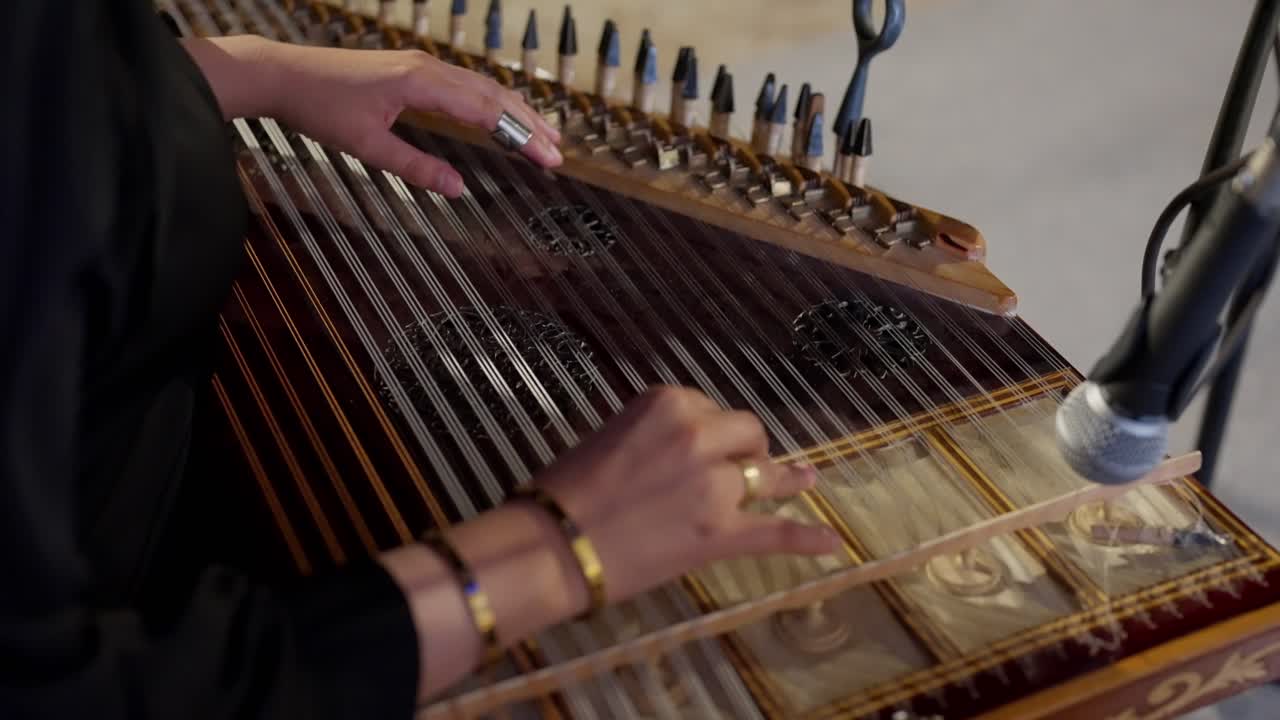 A woman playing on Zither in the theatre high angle shot, close up