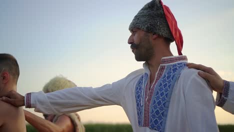 ukrainian cossacks sing a song in a field at sunset