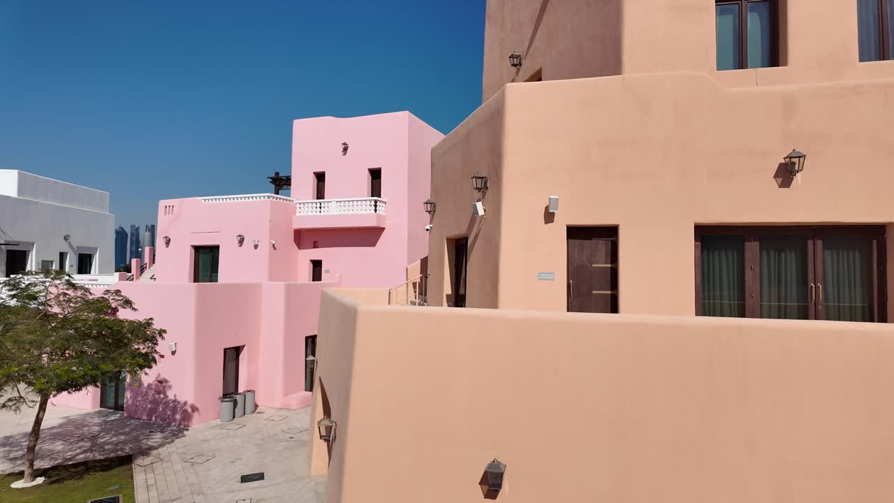 Peach-colored architectural buildings under a clear blue sky