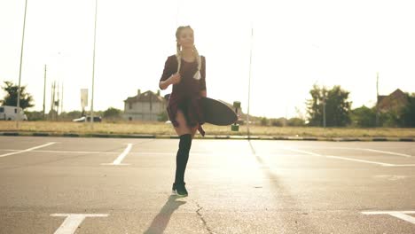 Joven-Hipster-Feliz-Está-Caminando-En-El-Estacionamiento-Sonriendo-Y-Mirando-A-La-Cámara-Durante-La-Puesta-De-Sol