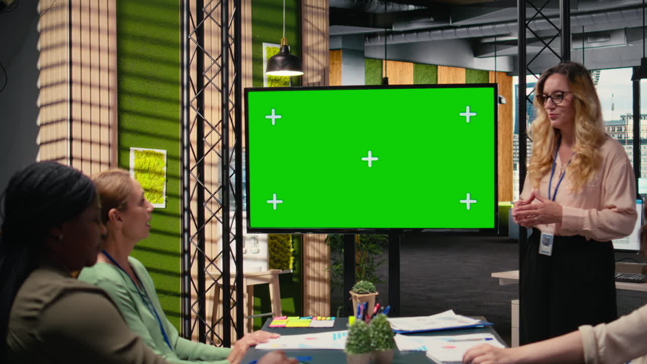 Manager and staff members using copy space on TV monitor during meeting