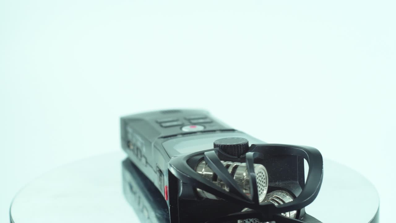 편리한 포켓 오디오 레코더, 블랙 사운드 스테레오폰, 반사 360도 회전 스탠드, 라인 인/아웃 녹색 포트, 볼륨 단추, 느린 동작, 4k 비디오의 클로즈업 샷