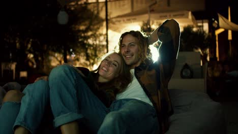 Close-up-shot:-a-couple-in-love-are-lying-on-beanbag-chairs-and-watching-a-movie.-Rest-at-the-weekend