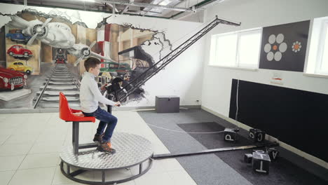 Museum of Science. Boy sitting in simulator of excavator and playing with joystick. Concept of physics