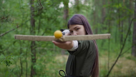 Girl-with-purple-hair-in-medieval-dress-aims-from-crossbow