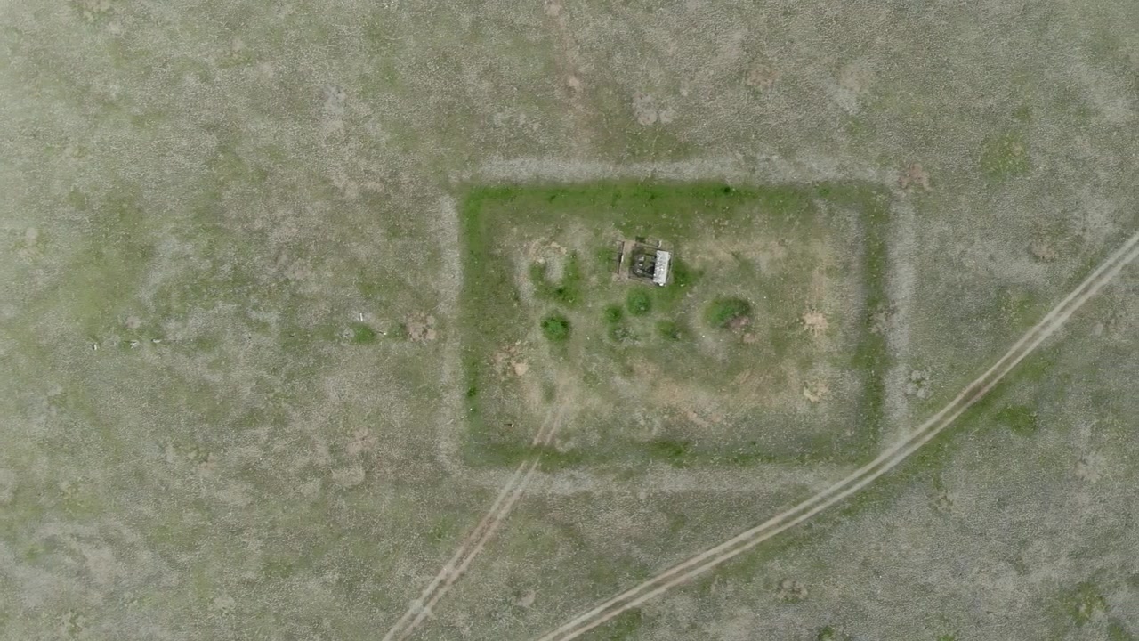 Aerial View of a Remote Rectangular Enclosure in a Grassy Field