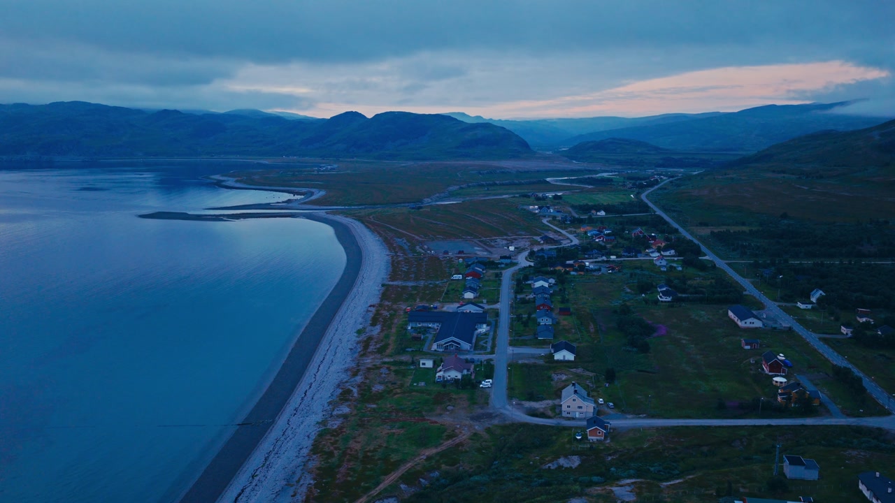 Kokelv, Hammerfest, Finnmark, Norway - The Village Rests Along the Coast, With Winding Roads and Colorful Houses Nestled Between the Water and Hills - Orbit Drone Shot