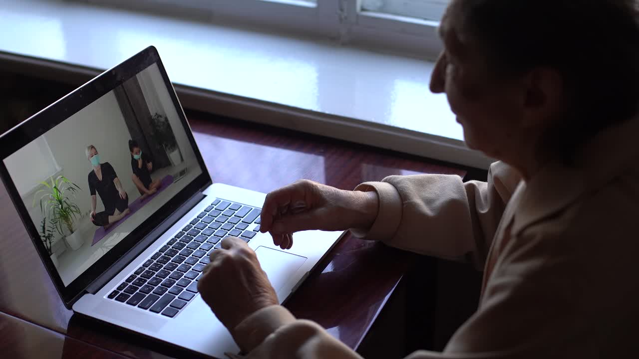 an elderly woman looking at a laptop about covid