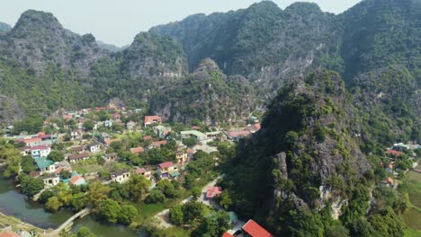 drone aéreo que se aleja de una gran montaña de piedra caliza con un templo del dragón en vietnam