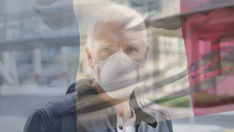 animation of flag of france waving over man wearing face mask during covid 19 pandemic