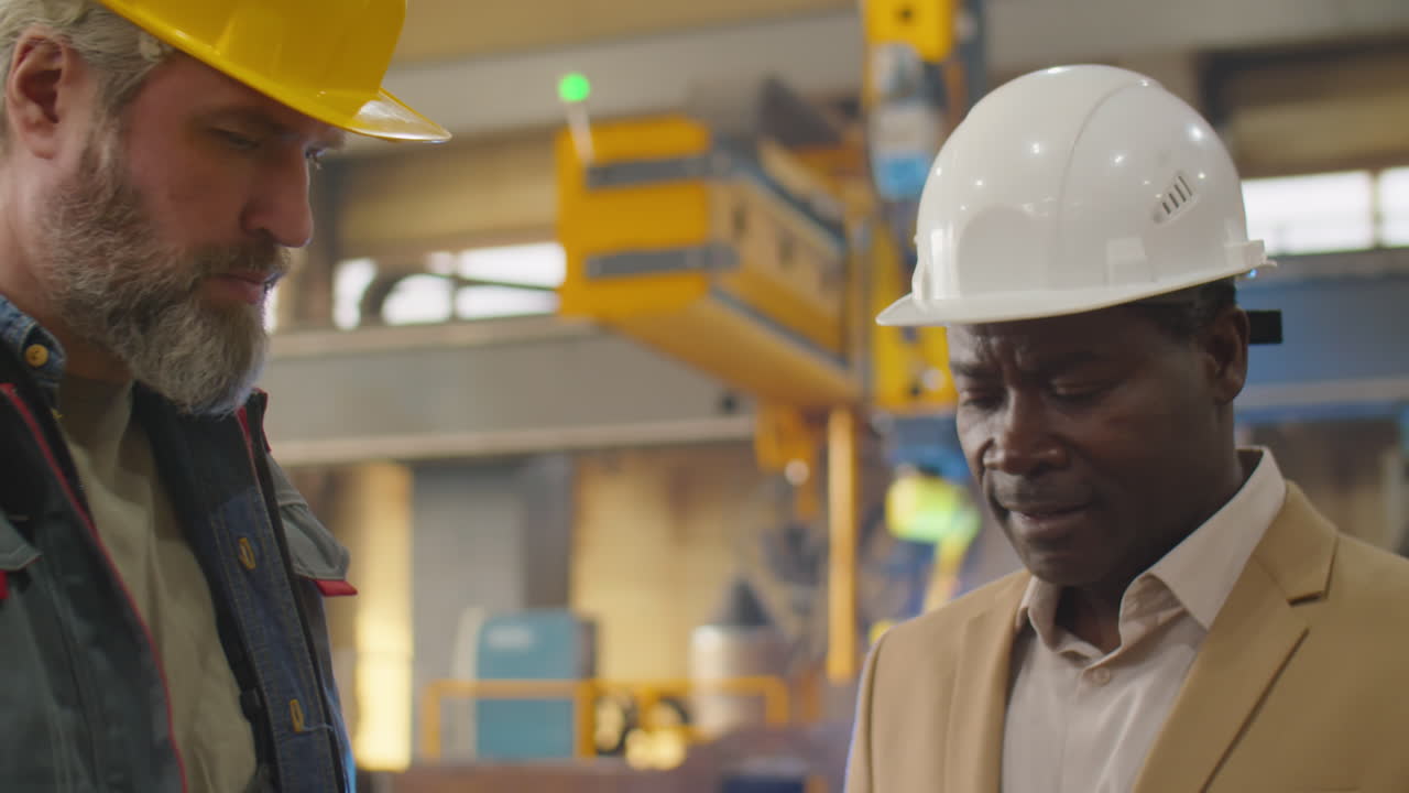 Ingegneri senior multietnici che discutono di lavoro in fabbrica