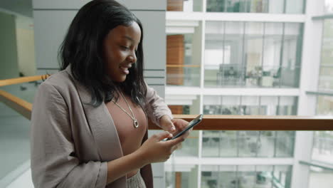 Mujer-Afroamericana-Escribiendo-En-Un-Smartphone-En-El-Centro-De-Negocios