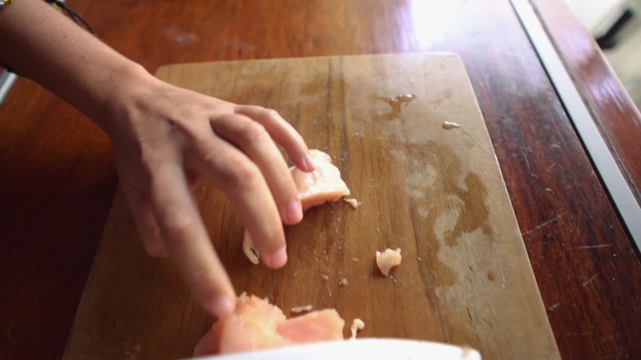 Young woman Hands cutting chicken On Cutting Board