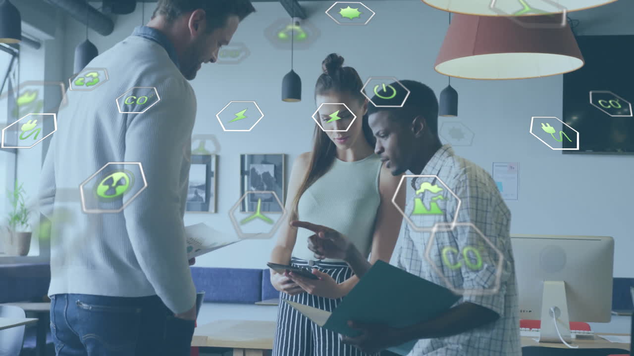 Animation of ecology icons over diverse colleagues discussing work in office