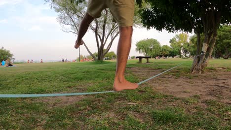 Nahaufnahme-Beine-Balancieren-Auf-Slackline-Im-Park-Im-Freien-Zwischen-Bäumen