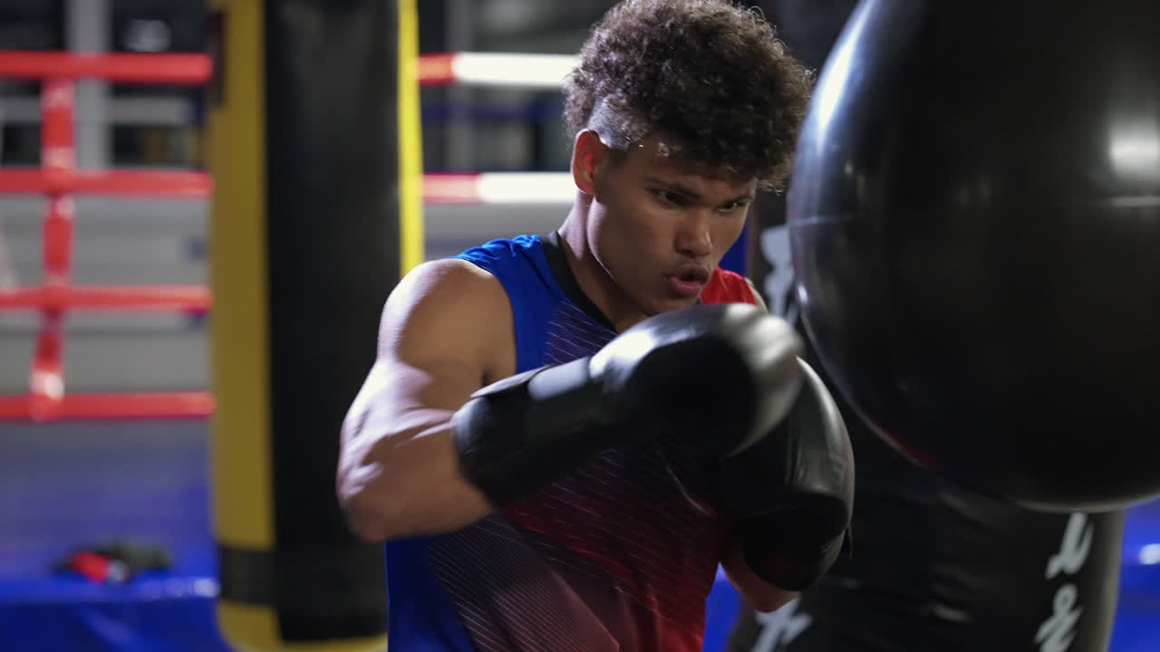 젊은 권투 선수가 권투 봉투를 가지고 훈련하고 있습니다.