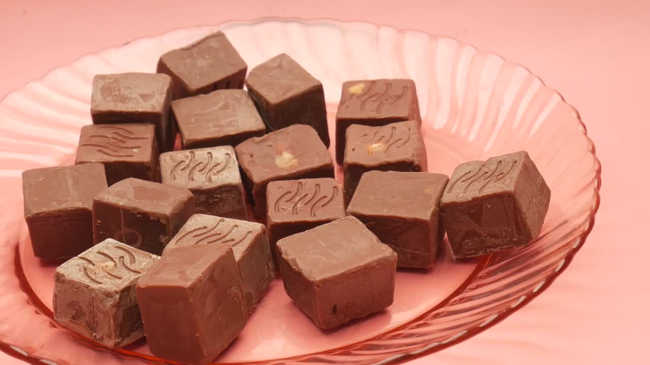 cuadrados de chocolate en un plato rosado