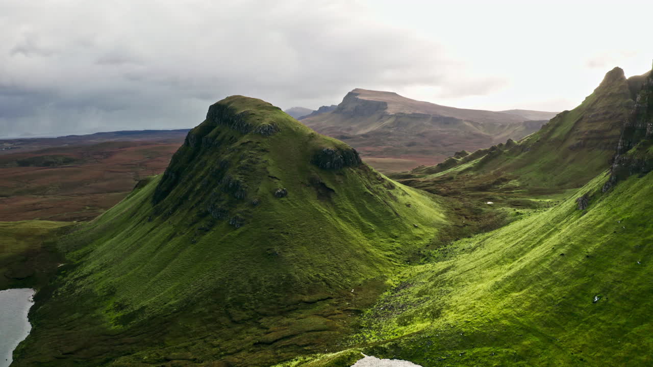 Lush Green Slopes And Rugged Peaks Of The Quiraing With Lochs. Isle Of Skye, Scotland, UK. aerial shot