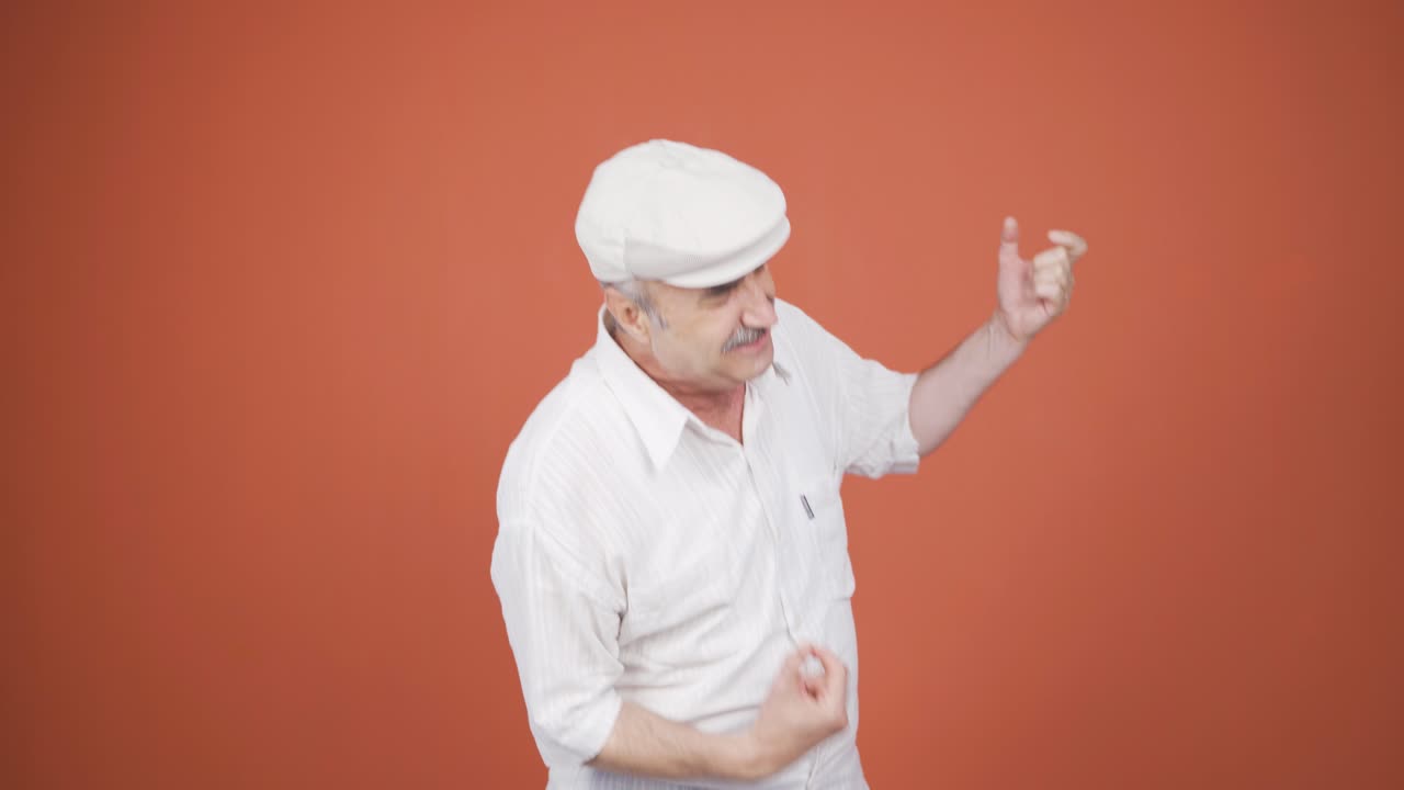 Anziano che fa il segno delle corna e balla