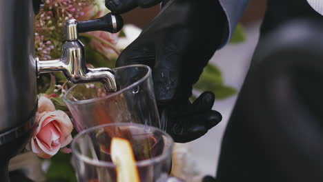 bartender-in-gloves-fills-glass-cup-with-tasty-mulled-wine