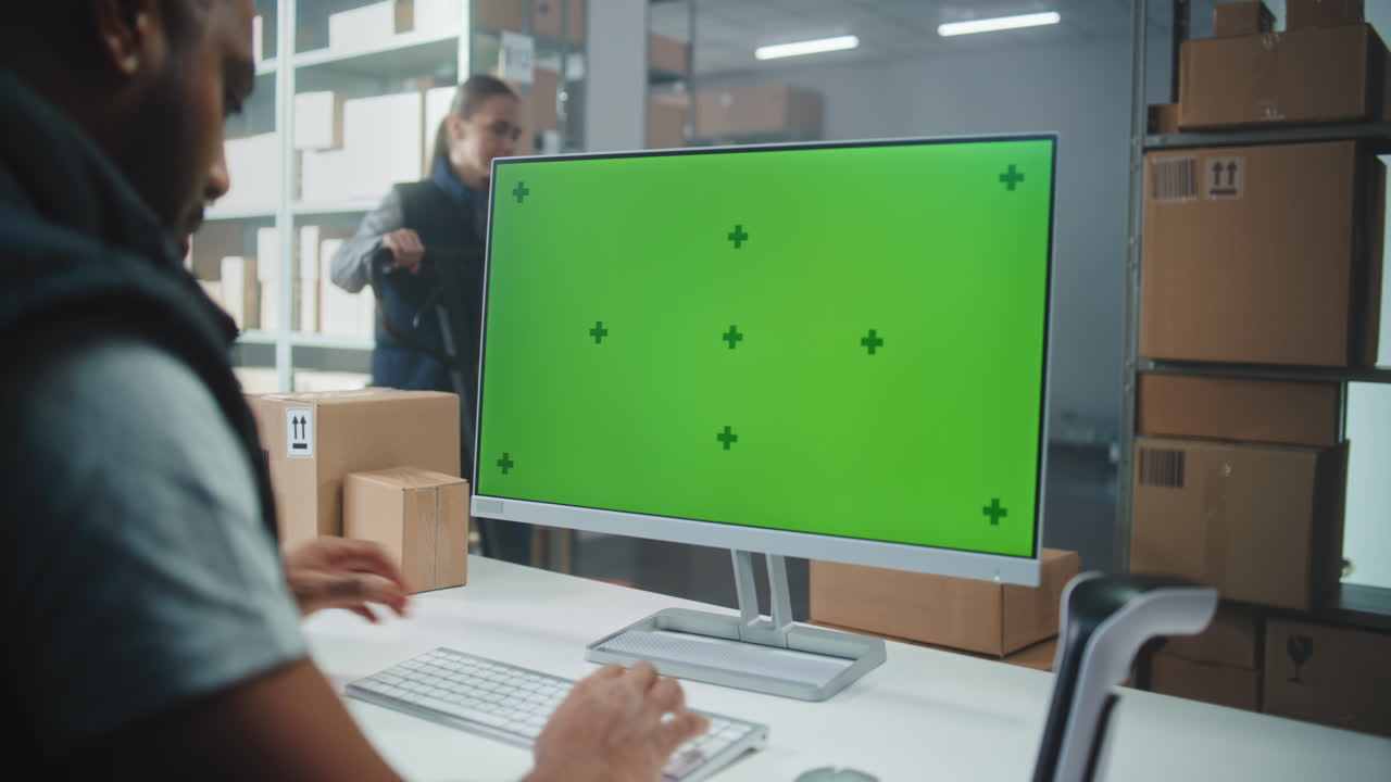 trabajador de almacén que utiliza una computadora con un monitor de pantalla verde