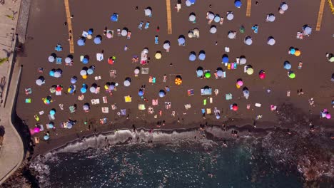 Colourful-umbrellas-on-a-sandy-beach-in-Tenerife,-captured-from-Top-Down-view