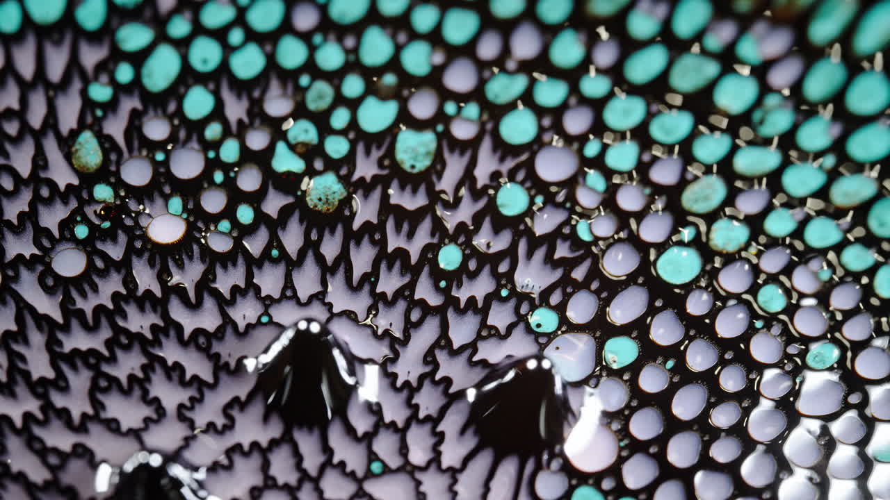 A close-up shot of colorful liquid droplets blending together with intricate patterns