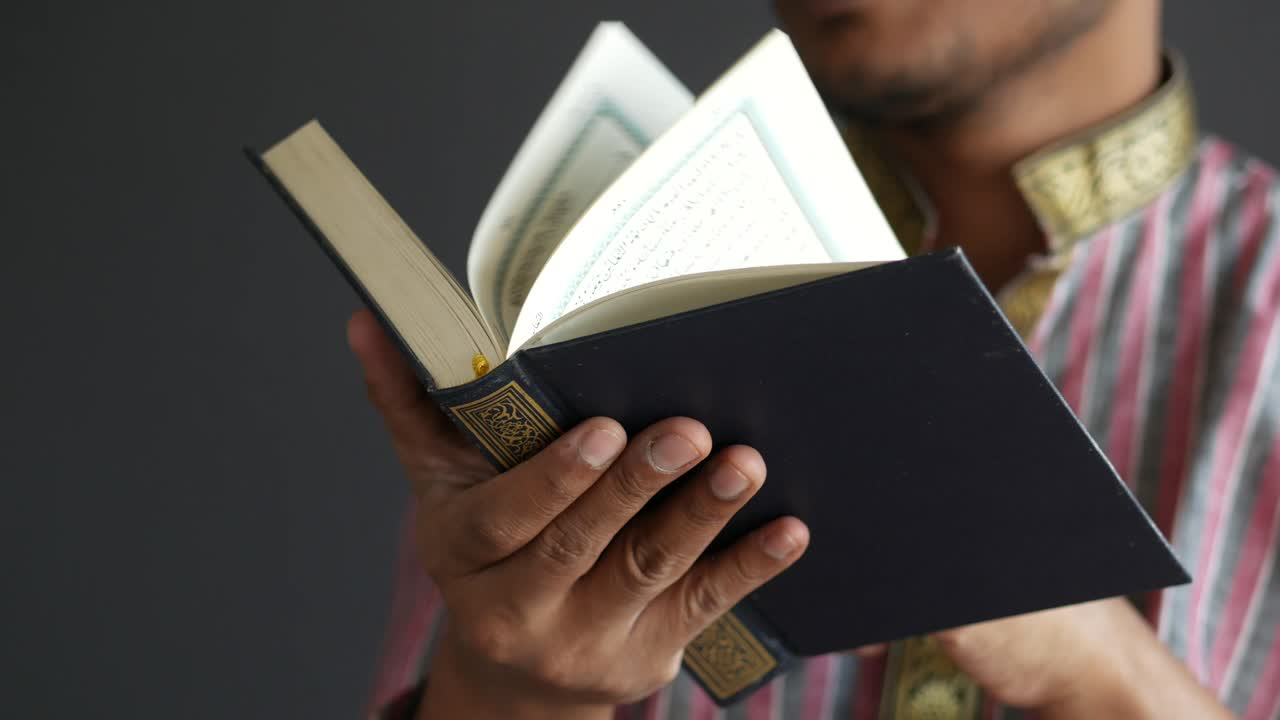 Müslüman adamın elinde Kur'an-ı Kerim, boşluklu