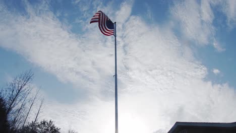 american flag waving on a sunny day under blue sky - wide shot