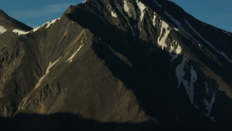 Aerial-cinematic-drone-sunrise-sunlight-early-morning-shadows-Grays-and-Torreys-14er-Peaks-Rocky-Mountains-Colorado-stunning-landscape-view-mid-summer-snow-on-top-zoom-slowly-pan-up-movement