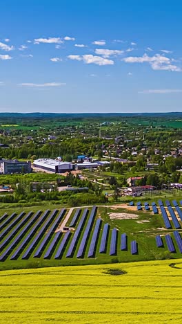 drone hyperlapse of solar panel farm near countryside town with canola fields and blue sky