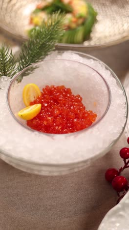 red caviar in ice bowl with lemon