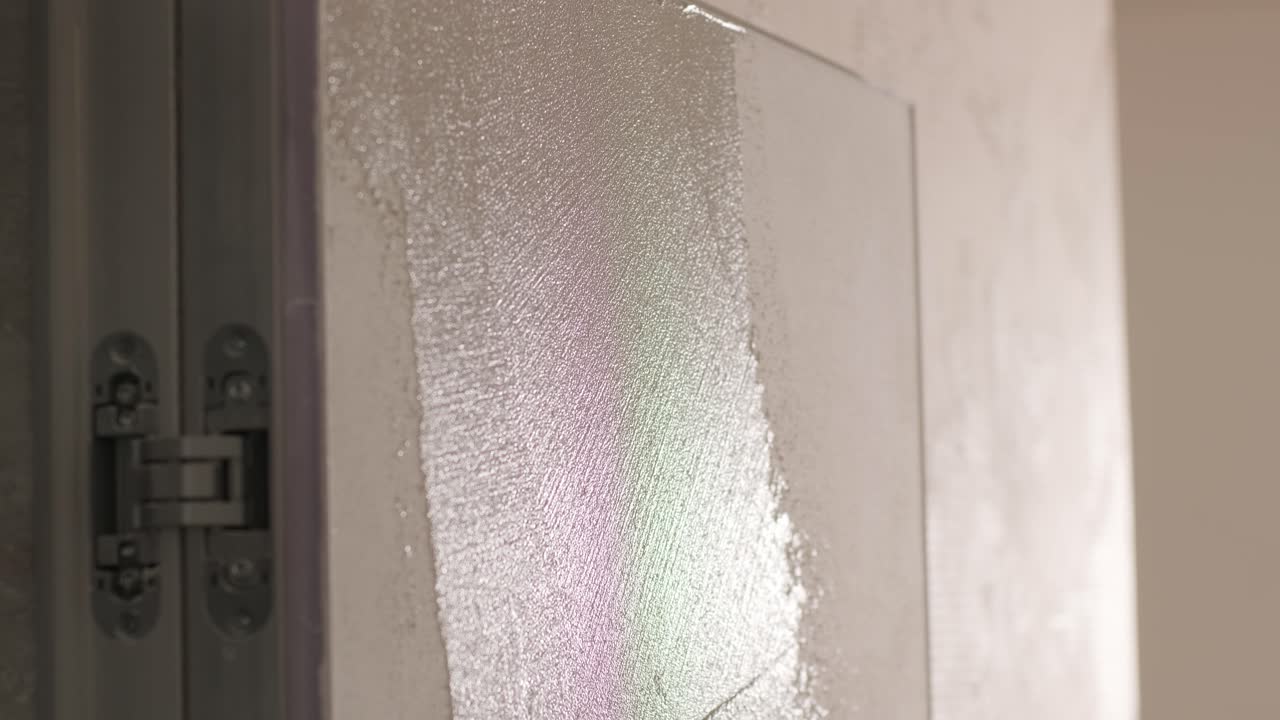 Worker applies decorative plaster with a thin spatula. Giving a unique texture to white walls. Venetian plaster