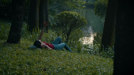 woman relaxing in a park by a pond