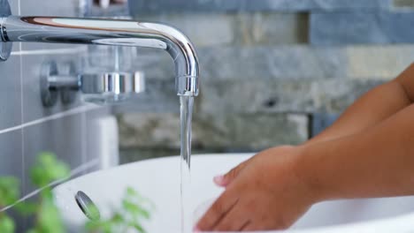 Girl-washing-hands-in-bathroom-sink-4k