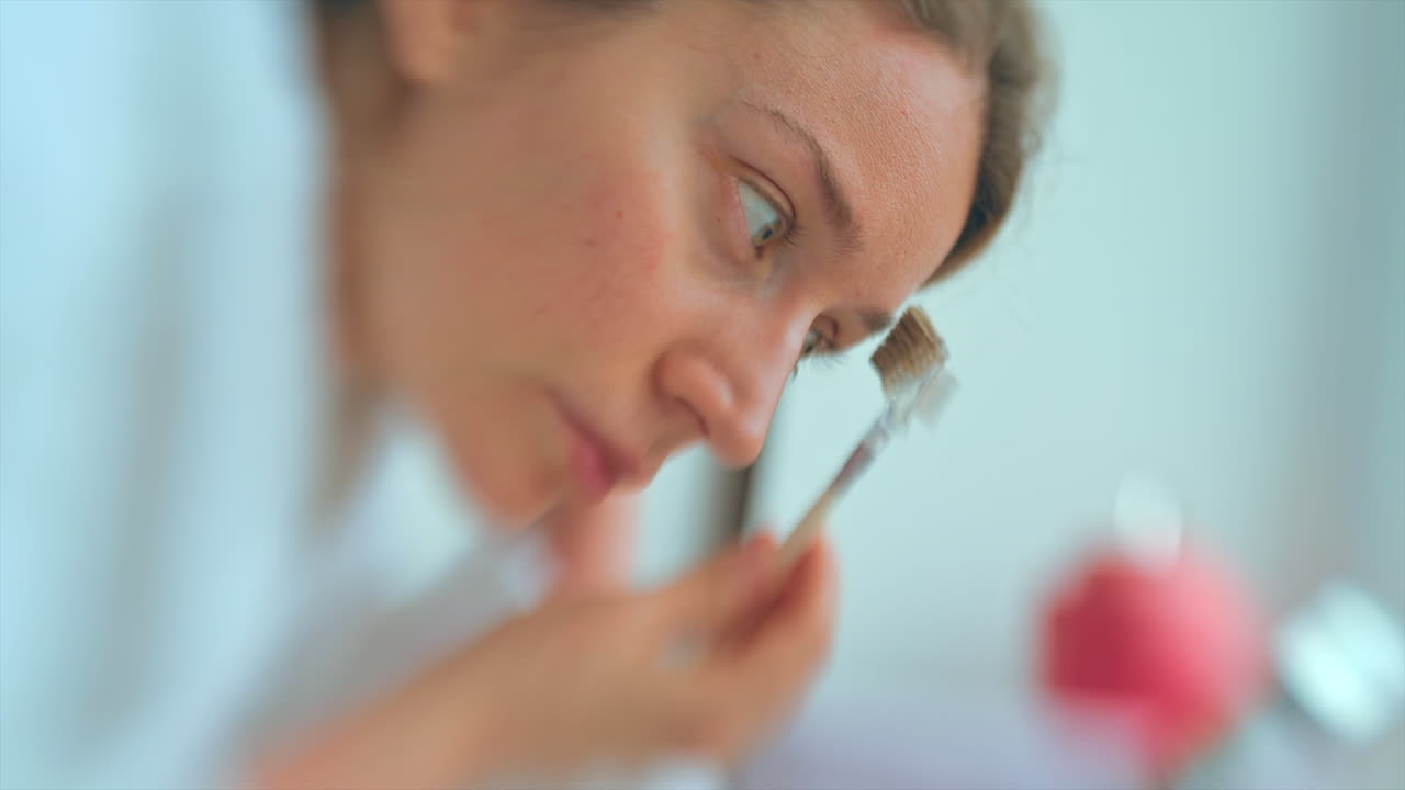 Woman shaping her eyebrows in the bathroom