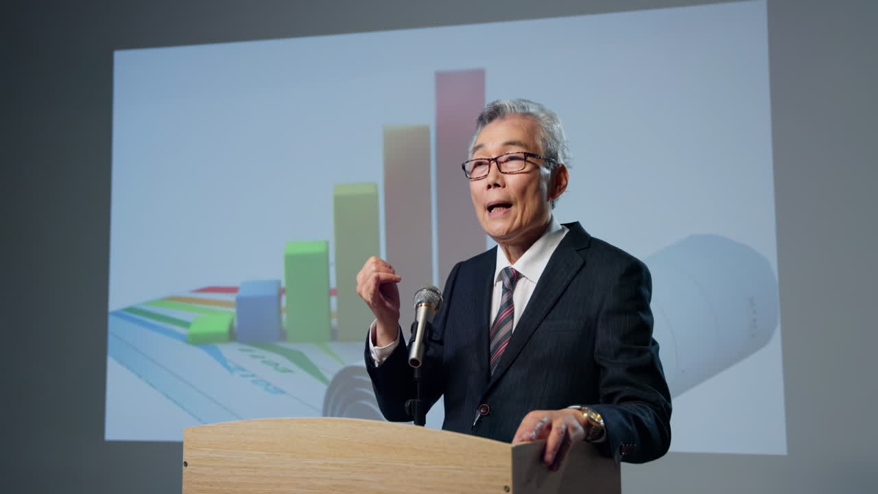 Mature financial consultant Public speaking from stage and Conference Presentation Speaker at Podium
