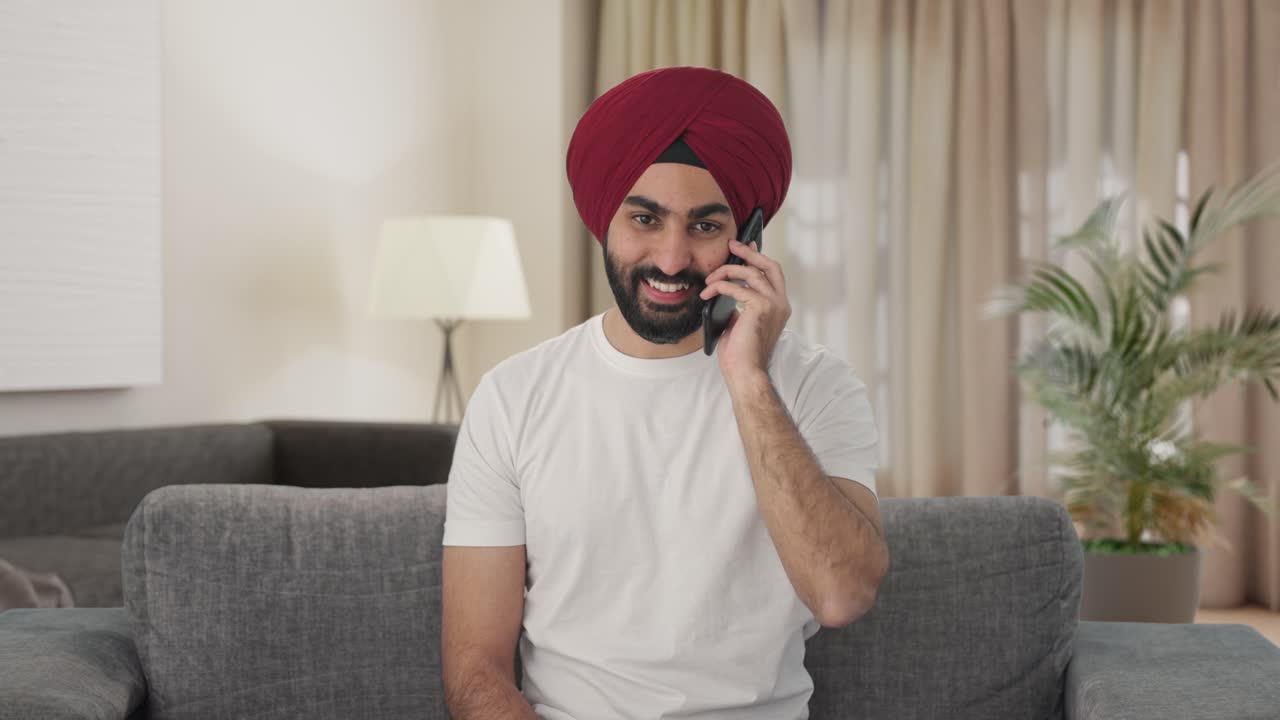 hombre indio sikh feliz hablando por teléfono